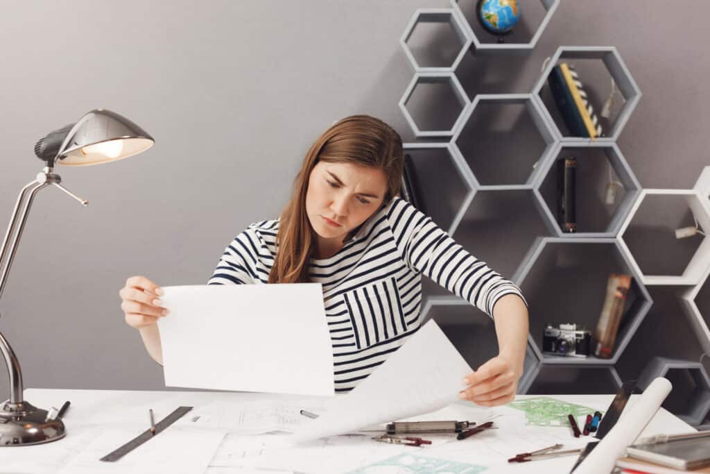 Student reviewing past papers at a desk, using them as part of their exam preparation