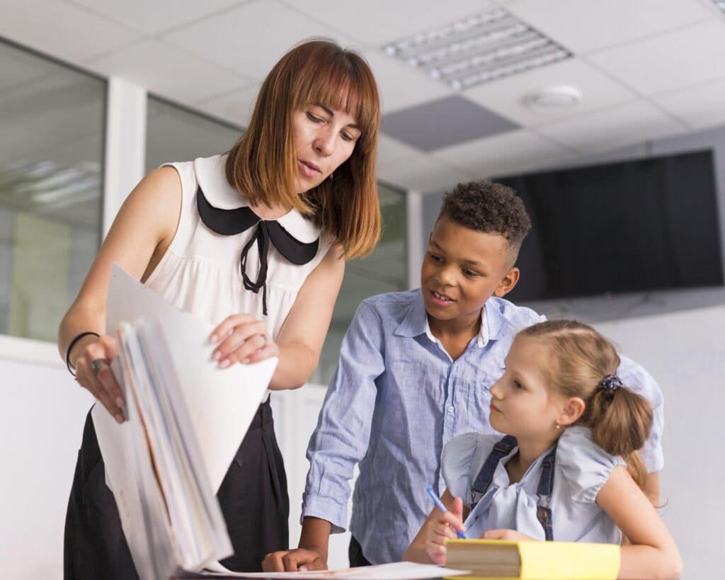 Teacher reviewing past papers with a group of students, using them to identify areas of weakness and tailor teaching materials